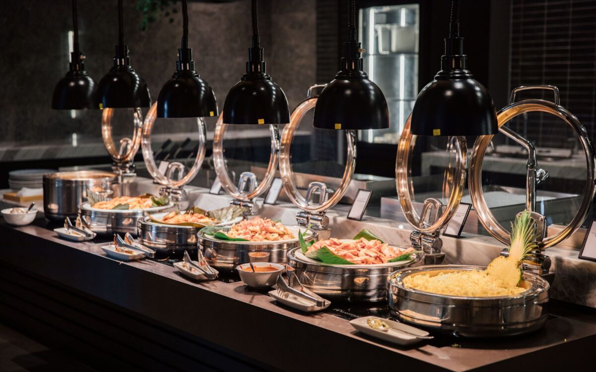 Um buffet belamente organizado com vários pratos sob iluminação quente, perfeito para fotografia de eventos ou hospitalidade
