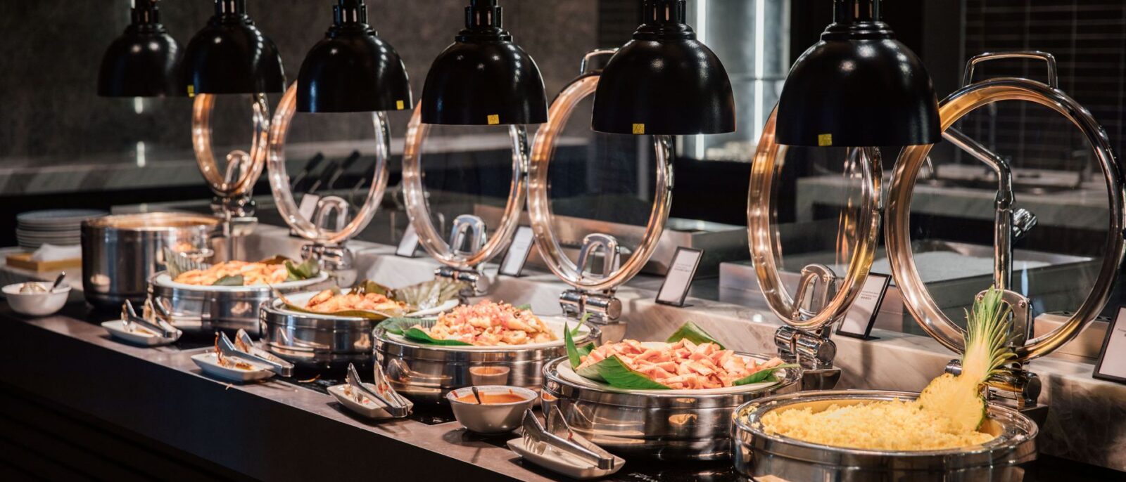 Um buffet belamente organizado com vários pratos sob iluminação quente, perfeito para fotografia de eventos ou hospitalidade