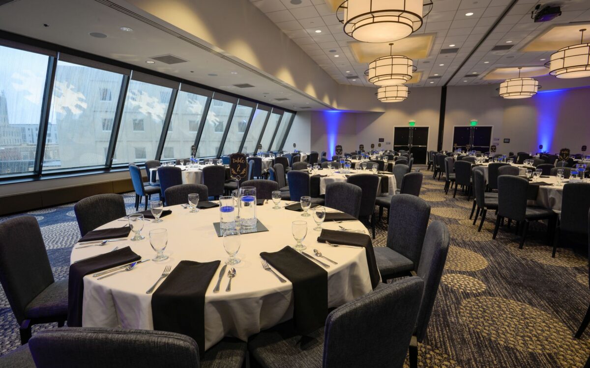 Espaçoso salão de banquetes com mesas redondas elegantemente arrumadas e iluminação interior moderna