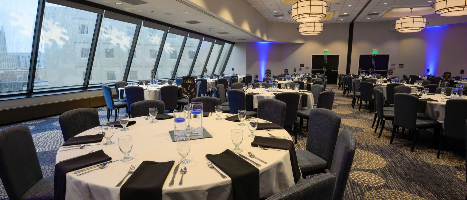Espaçoso salão de banquetes com mesas redondas elegantemente arrumadas e iluminação interior moderna