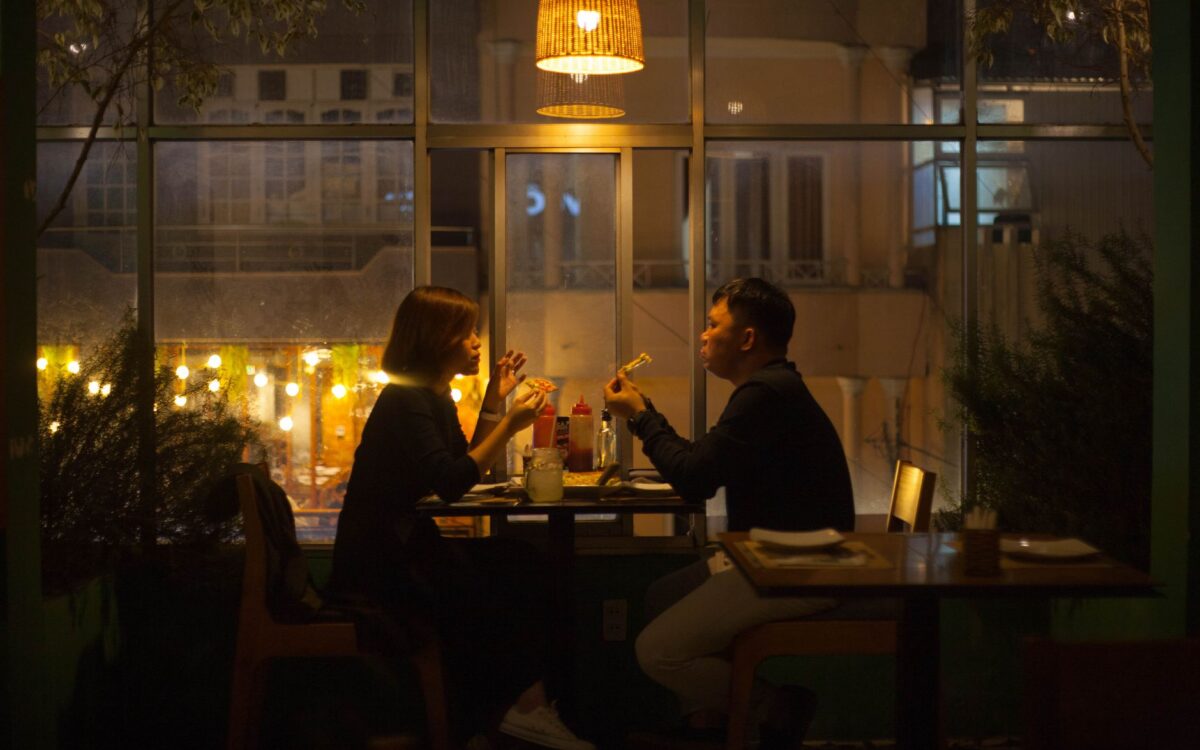 Um casal aprecia um jantar à luz de velas no interior aconchegante de um restaurante à noite