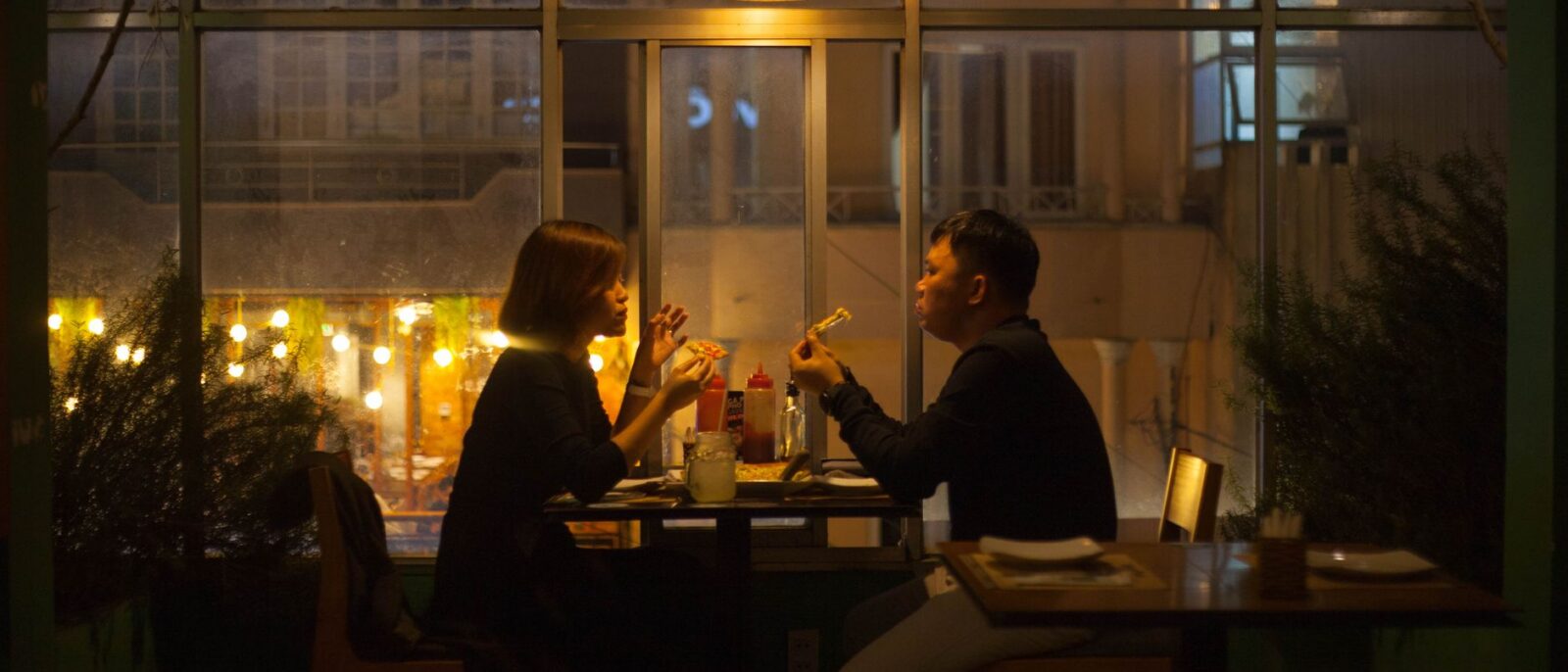 Um casal aprecia um jantar à luz de velas no interior aconchegante de um restaurante à noite